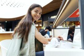 Woman studying using laptop computer sitting at the cafe. Young student learning language